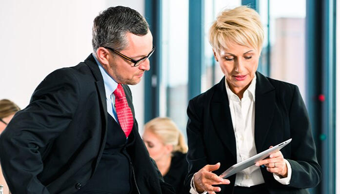 Corporate Sales Training and Leadership Communication Workshop A business leader and HR manager reviewing a sales training plan during a corporate communication workshop focused on performance and clarity.